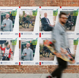 Ein Mann geht vor einer Wand entlang, an der viele Plakate der Kampagne "Und ob das geht" hängen